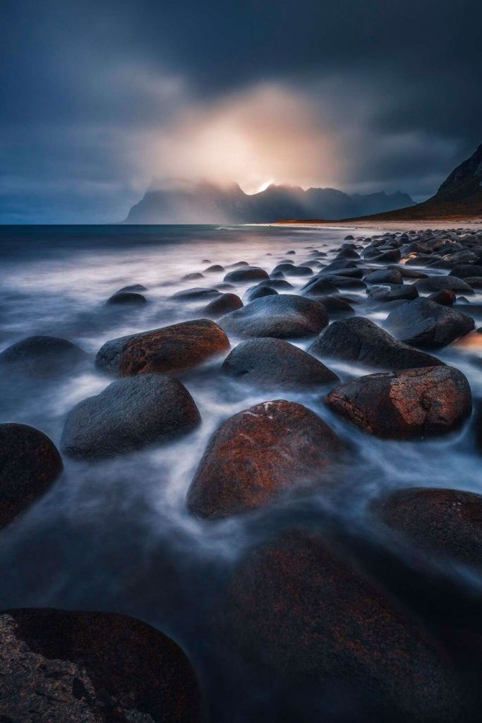 Światło wieczorne nad surowym wybrzeżem z kamieni.