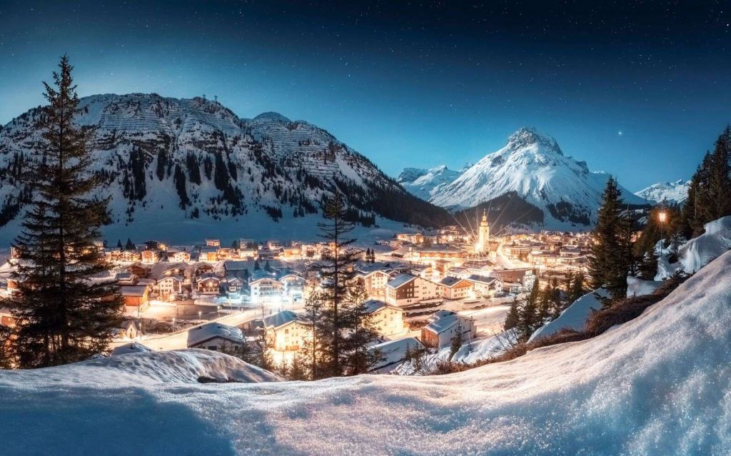 Błyszcząca alpejska wioska pod gwiaździstym niebem.