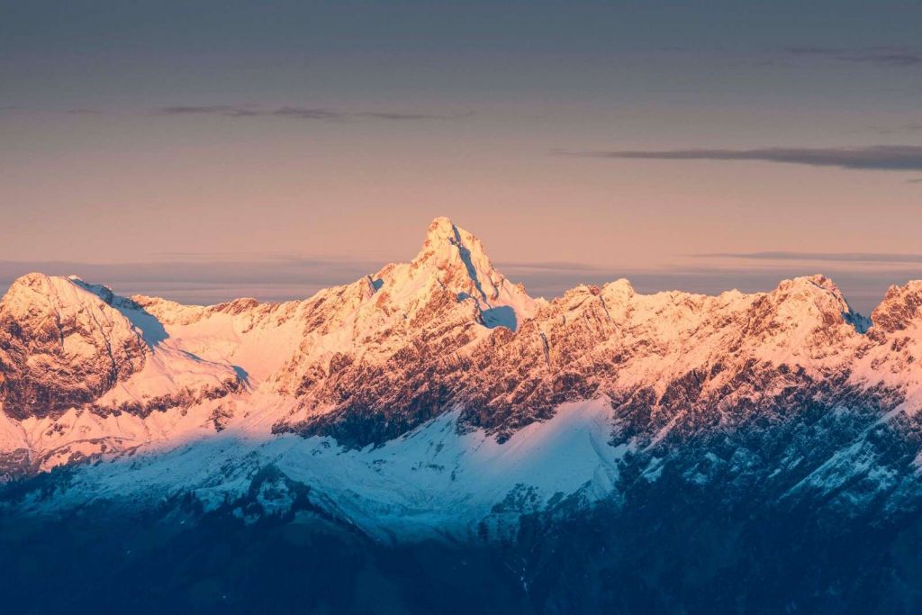 Światło wieczorne na zaśnieżonych szczytach gór.