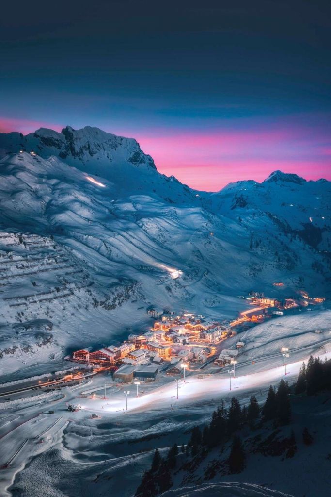 Miasteczko śnieżne pod fioletowym wieczornym niebem.
