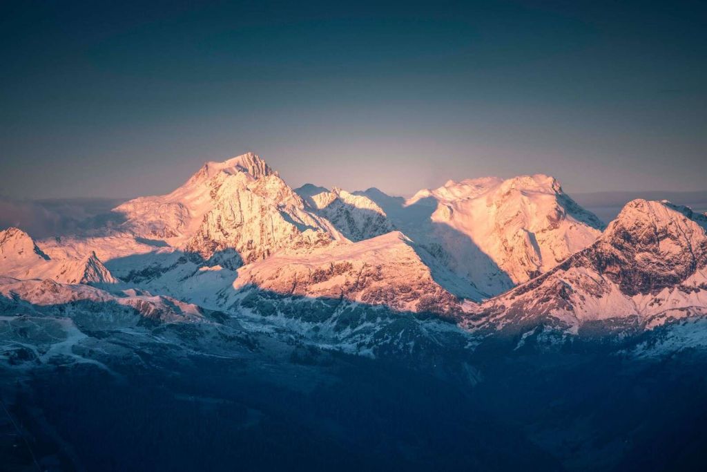 Światło poranne na zaśnieżonych szczytach gór.