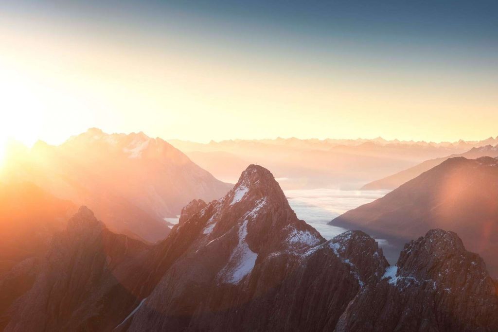 Wschód słońca nad konturami gór.