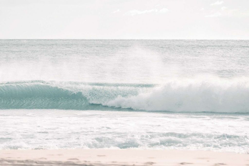 Rozbijająca się fala na jasnej plaży