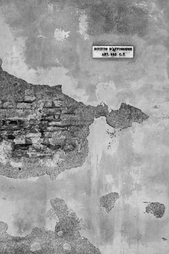 Zniszczona ściana z włoskim tekstem