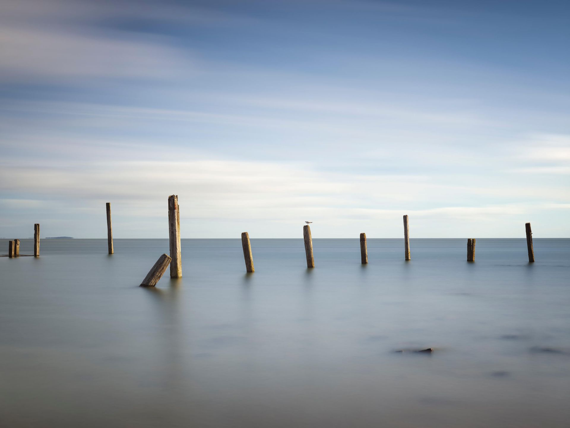 Stare drewniane słupy w morzu