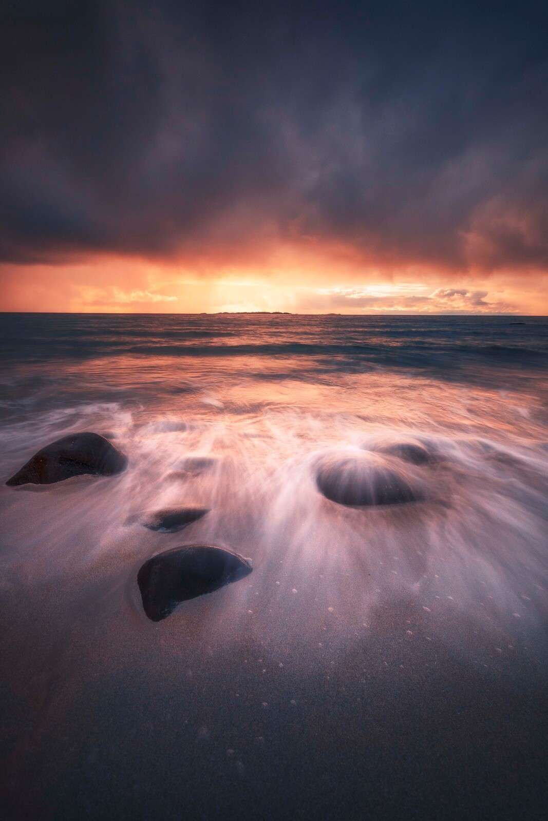 Zachód słońca nad kamienistym wybrzeżem