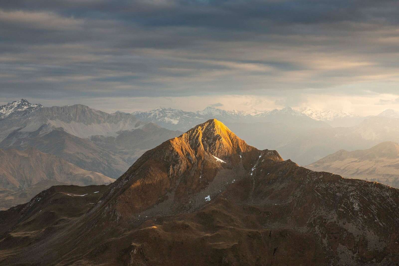 Złote światło słoneczne na szczycie góry o wschodzie słońca.
