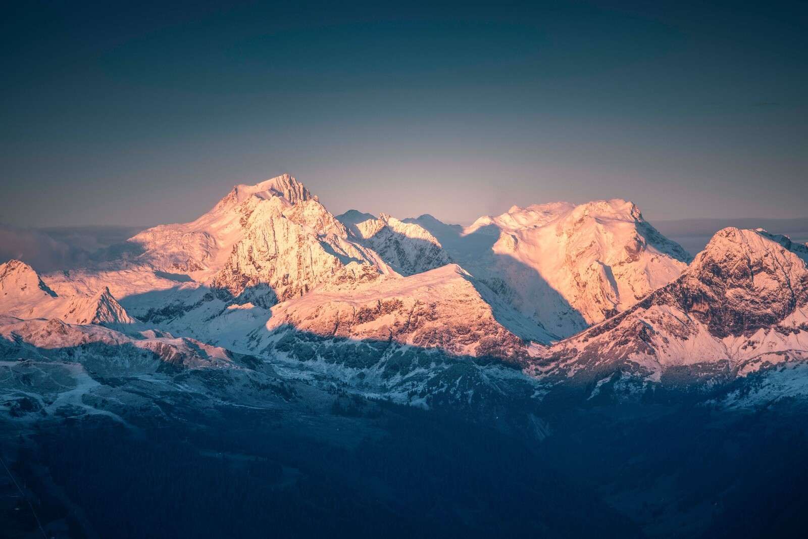 Światło poranne na zaśnieżonych szczytach gór.
