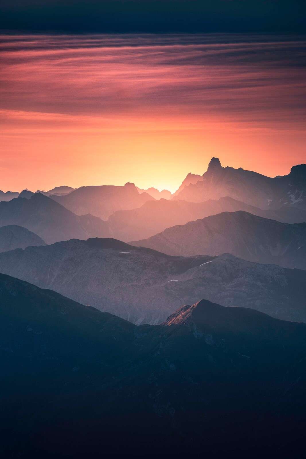 Wschód słońca nad fioletowymi zboczami gór.