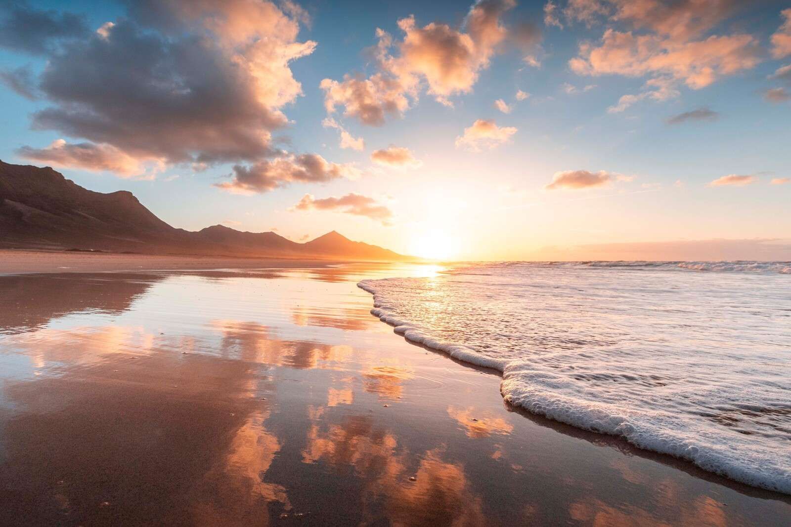 Złoty zachód słońca nad cichym wybrzeżem.