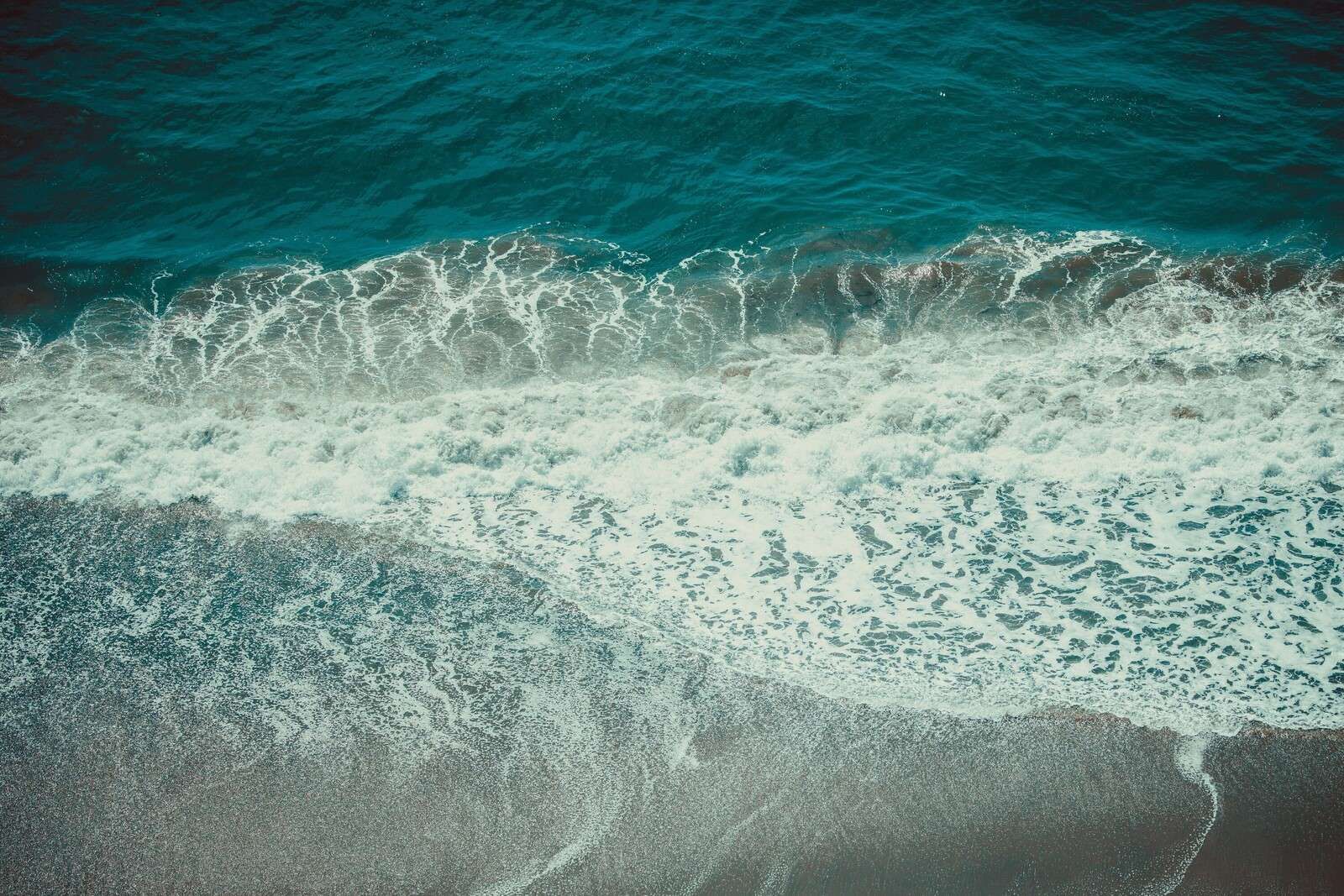 Pianie fal na mokrym piasku